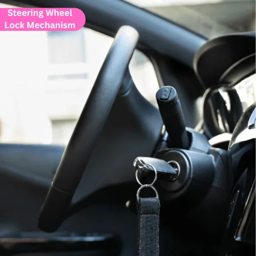 Photo of a car dashboard showing the steering wheel, ignition with a key inserted, and gear shifter, illustrating the steering wheel lock mechanism.