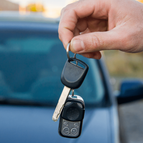 Person holding a laser-cut car key, an example used when explaining how a locksmith can make car keys