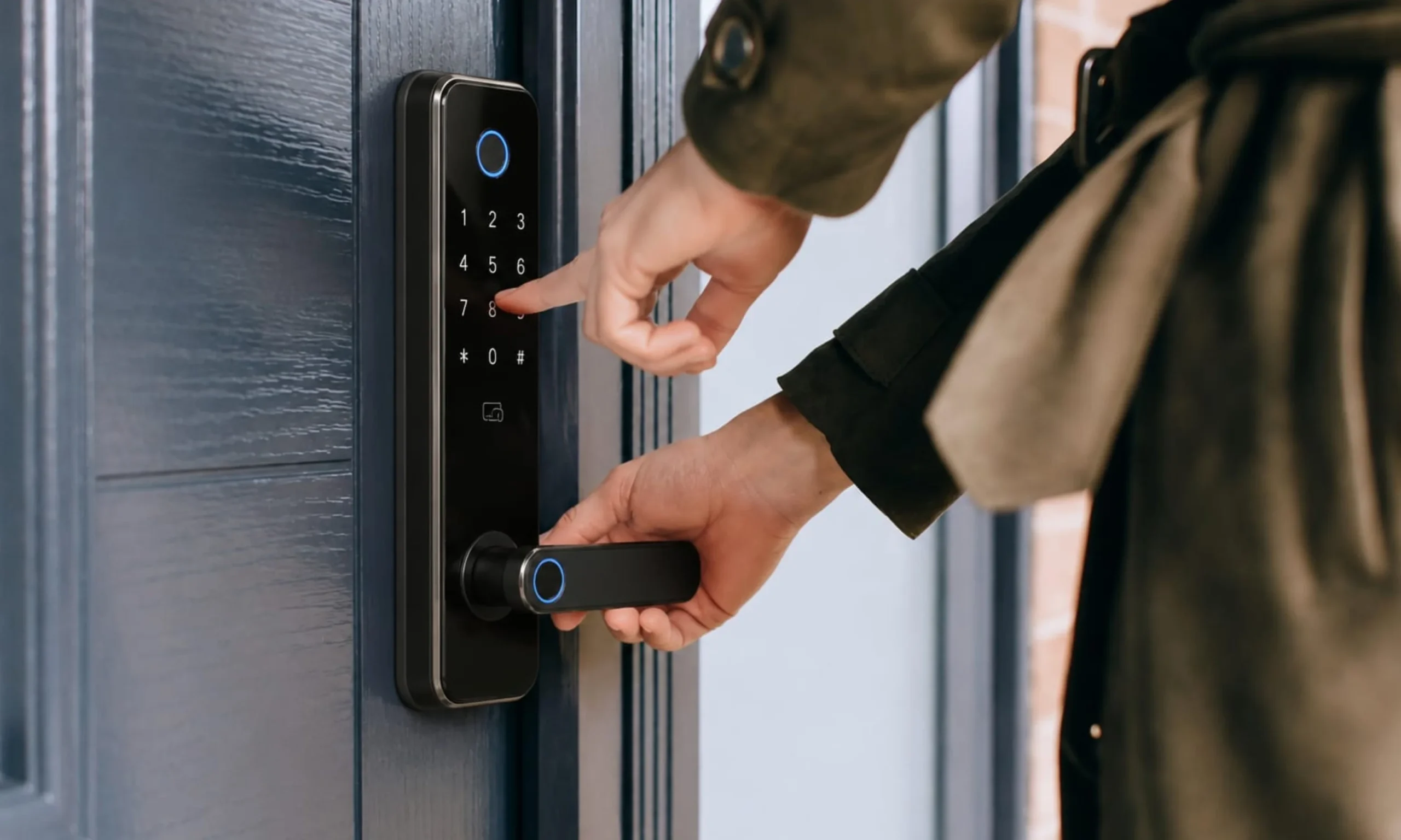 A close-up view of a person performing a final functionality test on a modern black smart lock installed on a dark blue residential front door. One hand presses the illuminated touchscreen keypad to enter a PIN code while the other hand grips the matching black lever handle, verifying that the configured access credentials and locking mechanism operate correctly. The sleek smart lock features a glossy touch-sensitive keypad, illuminated circular status indicators, and a minimalist contemporary design. Bright natural daylight highlights the clean entrance, while the focused composition emphasizes the process of confirming lock operation, access methods, and overall functionality before completing the installation, ensuring the smart lock is fully configured and working as intended.