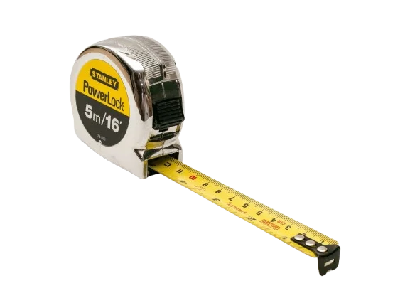 A studio photograph of a classic Stanley PowerLock tape measure isolated on a clean, solid white background. The tool features a durable, rounded metallic chrome-finished plastic housing that reflects light. The side of the casing displays a prominent circular label with a bright yellow top section showing the black "STANLEY" logo and a black bottom section with the silver and yellow text "PowerLock 5m/16'". A black plastic thumb lock switch is positioned on the front edge of the casing. A portion of the flexible yellow metal measuring blade is extended horizontally forward, revealing clear black and red measurement markings in both centimeters and inches. The blade ends with a riveted black metal hook lip pointing toward the bottom right corner.
