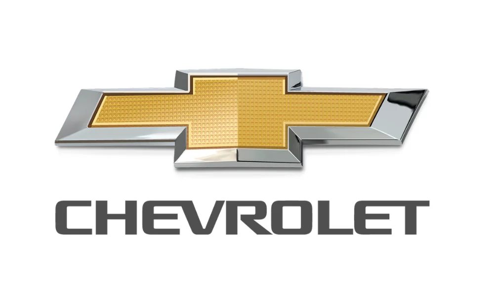 Chevrolet car logo featuring a gold cross-shaped emblem with a textured center and polished silver metallic border, displayed above the word “CHEVROLET” in dark gray uppercase lettering on a plain white background. The image represents the Chevrolet vehicle brand.