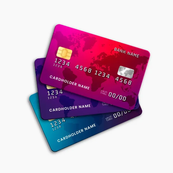 Three overlapping debit cards displayed diagonally on a plain white background. The front card has a bright pink and red gradient design with a darker red world map pattern across its surface. It has a gold EMV chip on the upper left, a silver rectangular payment strip on the upper right, and white sample card numbers reading “1234 1234 4568 4568” across the center. The words “BANK NAME” appear near the upper right, while “CARDHOLDER NAME” is printed toward the lower left. Near the bottom right, the card shows the sample expiration text “VALID THRU 00/00.” A dark purple card is partially visible underneath the front card, with similar sample numbers, cardholder text, and expiration information. A blue card appears at the bottom, also featuring a gold chip, sample card numbers, “CARDHOLDER NAME,” and “VALID THRU 00/00” text. The three cards are layered at slightly different angles, with the pink and red card most prominent in the foreground. The image visually represents debit card payment as one of the payment methods accepted by Quickey Locksmith Services.