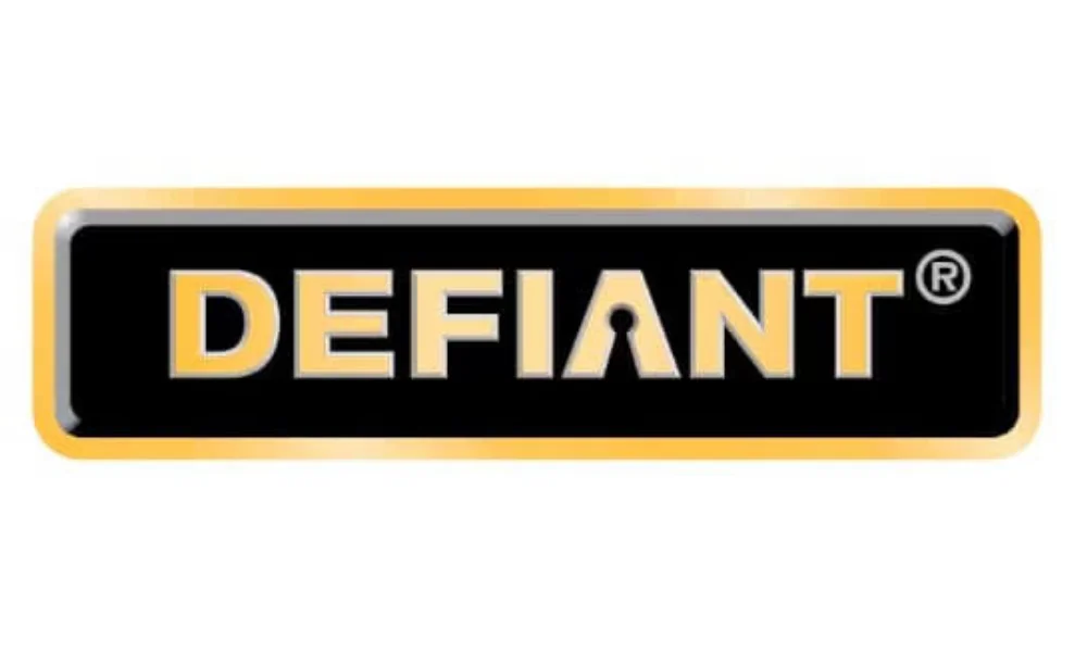 Defiant lock logo featuring the word “DEFIANT” in bold yellow-gold uppercase lettering, with the letter “A” incorporating a black keyhole design, centered inside a black rectangular panel with a yellow-gold border and subtle gray edging on a plain white background. The image represents the Defiant lock brand.