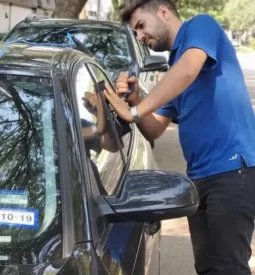 Emergency locksmith safely unlocking car door with professional tools during lockout